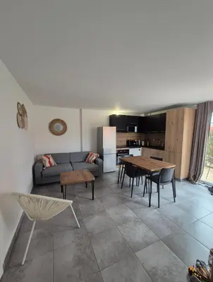 a living room with a couch and a table at Les hameaux de Saint Cyprien - appartement avec jardin et piscine in Lecci