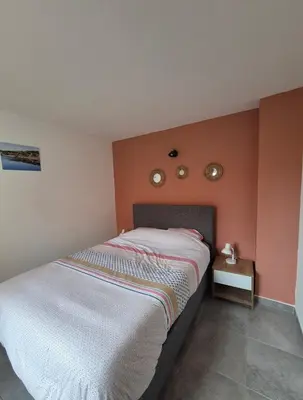 a bedroom with a bed and two clocks on the wall at Les hameaux de Saint Cyprien - appartement avec jardin et piscine in Lecci