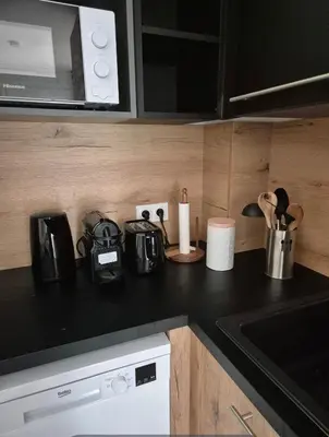 a kitchen with a counter top with a microwave at Les hameaux de Saint Cyprien - appartement avec jardin et piscine in Lecci