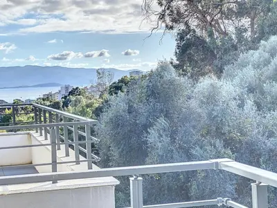 a patio with a table and chairs on a balcony at Appartement T2 standing in Ajaccio