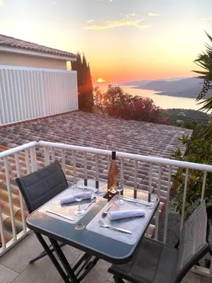 a table and chairs on a balcony with the sunset at Charmant appartement 3 étoiles entièrement rénové 