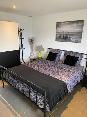 a bedroom with a large bed with purple sheets and a painting at Charmant appartement 3 étoiles entièrement rénové 