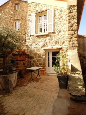 a stone house with a table in front of it at Entre mer et maquis in Appietto