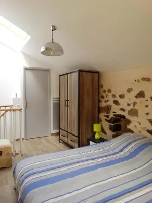 a bedroom with a bed and a wooden cabinet at Entre mer et maquis in Appietto