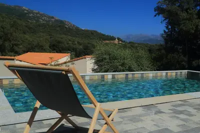 a chair sitting in front of a swimming pool at Le 42e Parallèle in Valle-di-Mezzana