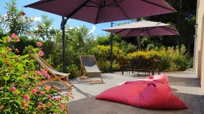 a red pillow sitting on the ground under an umbrella at Le 42e Parallèle in Valle-di-Mezzana