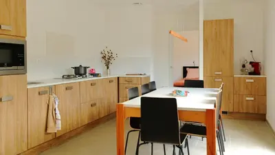 a kitchen with a table and chairs in a room at Le 42e Parallèle in Valle-di-Mezzana