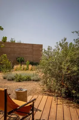 a wooden deck with a chair and a fence at Hôtel Mylos - Cargèse, Piscine Intérieure et Extérieure in Cargèse