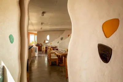 a room with a table and chairs and a wall at Hôtel Mylos - Cargèse, Piscine Intérieure et Extérieure in Cargèse