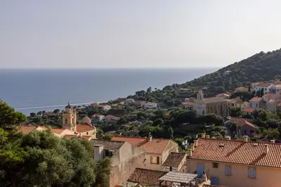 a view of a town with the ocean in the background at Hôtel Mylos - Cargèse, Piscine Intérieure et Extérieure in Cargèse