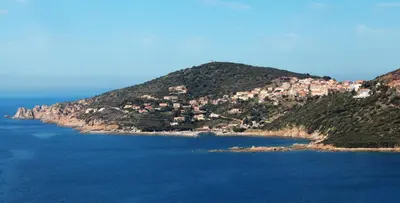 an island in the ocean with houses on a hill at Hôtel Mylos - Cargèse, Piscine Intérieure et Extérieure in Cargèse