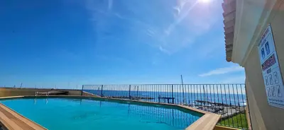 a swimming pool with the ocean in the background at Appartement VOILES BLANCHES-Clim-Wifi-Plage a pieds in Sari Solenzara