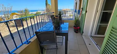 a table and chairs on a balcony with a view of the ocean at Appartement VOILES BLANCHES-Clim-Wifi-Plage a pieds in Sari Solenzara