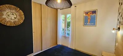 a hallway with a blue carpet and a clock on the wall at Appartement VOILES BLANCHES-Clim-Wifi-Plage a pieds in Sari Solenzara