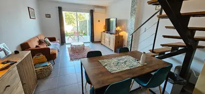 a living room with a table and a couch at VERANU - Vue campagne- 5 mn de la plage de sable in Prunelli-di-Fiumorbo
