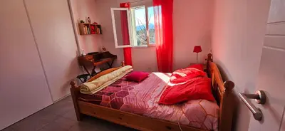 a bedroom with a bed with red sheets and a window at VERANU - Vue campagne- 5 mn de la plage de sable in Prunelli-di-Fiumorbo