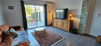 a living room with a couch and a flat screen tv at VERANU - Vue campagne- 5 mn de la plage de sable in Prunelli-di-Fiumorbo