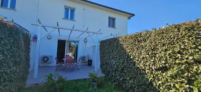 a white house with a hedge in front of it at VERANU - Vue campagne- 5 mn de la plage de sable in Prunelli-di-Fiumorbo