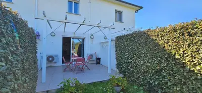 a white house with a patio and a hedge at VERANU - Vue campagne- 5 mn de la plage de sable in Prunelli-di-Fiumorbo