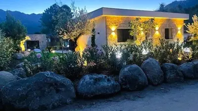 a house with a bunch of rocks in front of it at Villa Isula Bella, 8 pers, piscine chauffée, proche plage in Sainte-Lucie de Porto-Vecchio
