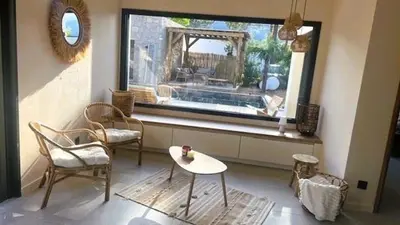 a living room with a table and chairs and a window at Villa Isula Bella, 8 pers, piscine chauffée, proche plage in Sainte-Lucie de Porto-Vecchio