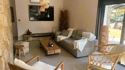 a living room with a couch and a table at Villa Isula Bella, 8 pers, piscine chauffée, proche plage in Sainte-Lucie de Porto-Vecchio