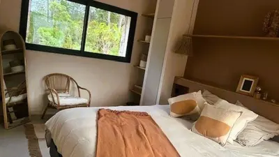 a bedroom with a bed with a window and a chair at Villa Isula Bella, 8 pers, piscine chauffée, proche plage in Sainte-Lucie de Porto-Vecchio