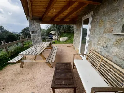 a group of benches sitting on a patio at Authentique Casellu en pierre à Porticcio avec vue sur la mer in Porticcio