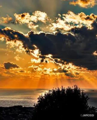 a sunset over the ocean with clouds in the sky at Authentique Casellu en pierre à Porticcio avec vue sur la mer in Porticcio