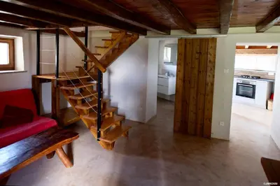 a living room with a spiral staircase in a house at Authentique Casellu en pierre à Porticcio avec vue sur la mer in Porticcio