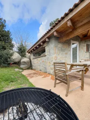 a grill with a bench next to a house at Authentique Casellu en pierre à Porticcio avec vue sur la mer in Porticcio