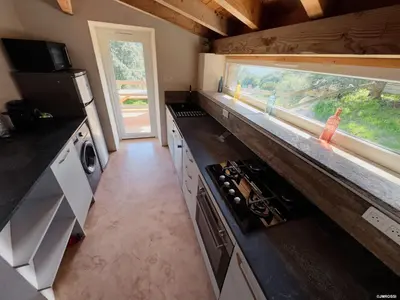 a kitchen with a counter top and a window at Authentique Casellu en pierre à Porticcio avec vue sur la mer in Porticcio