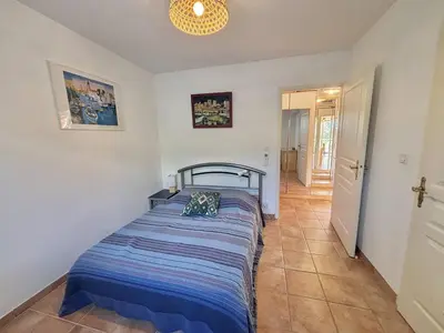a bedroom with a bed with a blue comforter at Villa 