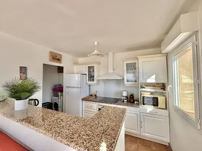 a kitchen with white cabinets and a granite counter top at Villa 