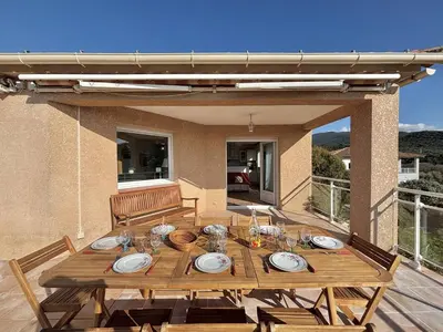 a wooden table with plates and glasses on a patio at Villa 
