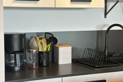 a kitchen counter with utensils in a container at Cosy T2 vue mer climatisé wifi et tout équipé refait à neuf in Ajaccio