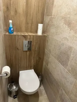 a bathroom with a toilet and a tiled wall at Cosy T2 vue mer climatisé wifi et tout équipé refait à neuf in Ajaccio