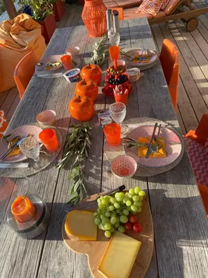 a wooden table topped with plates of food and fruit at Neues, modernes Steinchalet mit grosser Terrasse und Pool bei Rondinara in Bonifacio