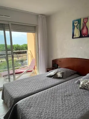a bedroom with a bed and a view of a balcony at Ajaccio appartement vue mer in Ajaccio
