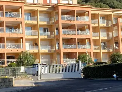 an apartment building with a white fence in front of it at Ajaccio appartement vue mer in Ajaccio