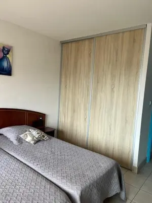 a bedroom with a bed and a wooden wall at Ajaccio appartement vue mer in Ajaccio