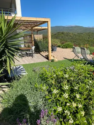 a garden with chairs and a table and some flowers at Magnifique appartement vue mer et montagne à Solenzara Corse in Sari Solenzara
