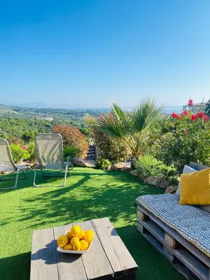 a table with a bowl of fruit on a lawn at Magnifique appartement vue mer et montagne à Solenzara Corse in Sari Solenzara