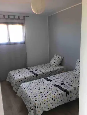 two twin beds in a room with a window at Magnifique appartement vue mer et montagne à Solenzara Corse in Sari Solenzara