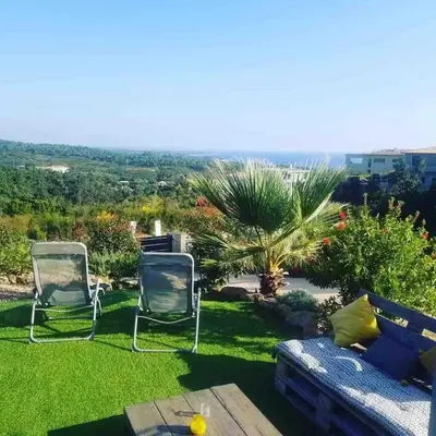 two chairs and a couch in a yard at Beautiful apartment U Mare sea and mountain view in Sari Solenzara
