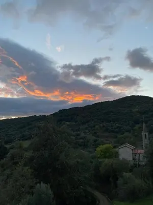 a sunset over a hill with a house and a road at Village vacations in Guarguale