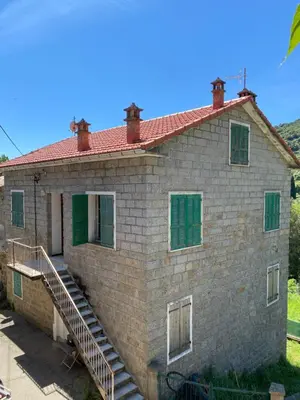 an old brick house with green shutters and stairs at Village vacations in Guarguale