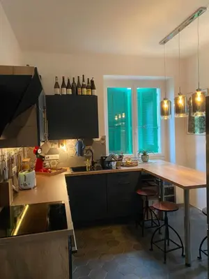 a kitchen with a counter and a table with bar stools at Village vacations in Guarguale