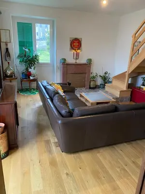 a living room with a black leather couch and stairs at Village vacations in Guarguale