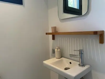 a bathroom with a sink and a tv on the wall at A Casuccia in Zonza